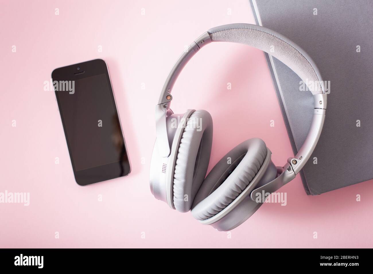 Hörbuchkonzept moderne drahtlose Kopfhörer Smartphone und Buch Stockfoto