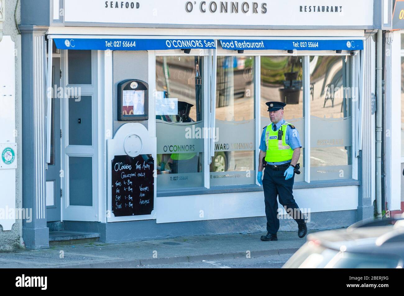 Bantry, West Cork, Irland. April 2020. Ein Garda trägt Schutzhandschuhe und patrouilliert heute den Bantry Square. Quelle: AG NewsAlamy Live News Stockfoto