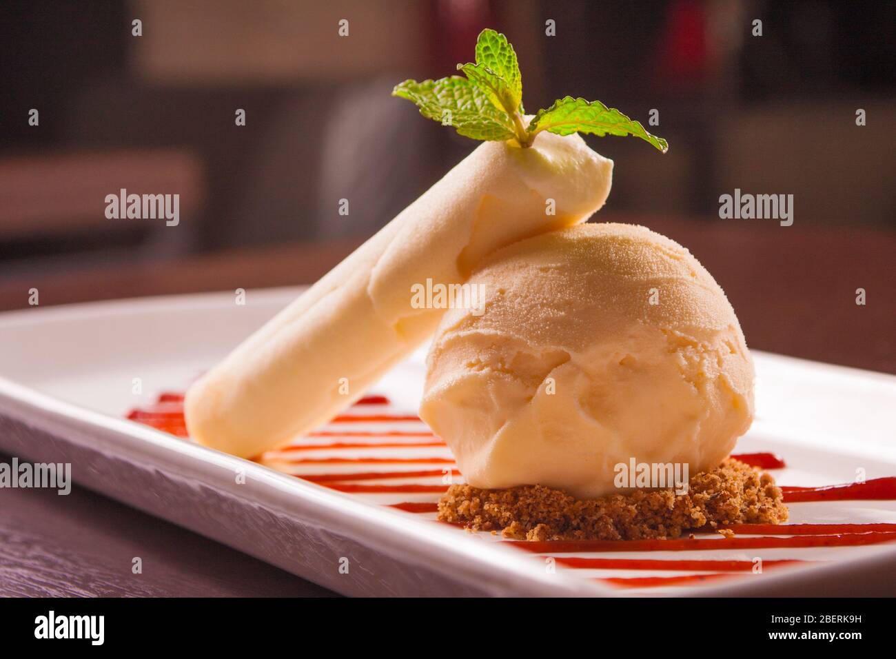 Vanille Eis mit Nüssen und Erdbeersirup Stockfoto