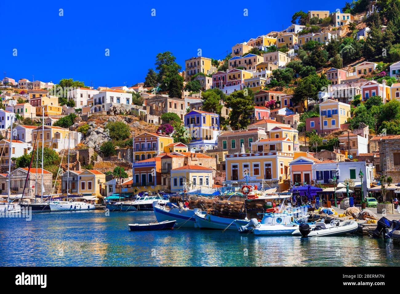 Bunte traditionelle Häuser, Meer und Boote in Symi Insel, Dodekanes, Griechenland. Stockfoto