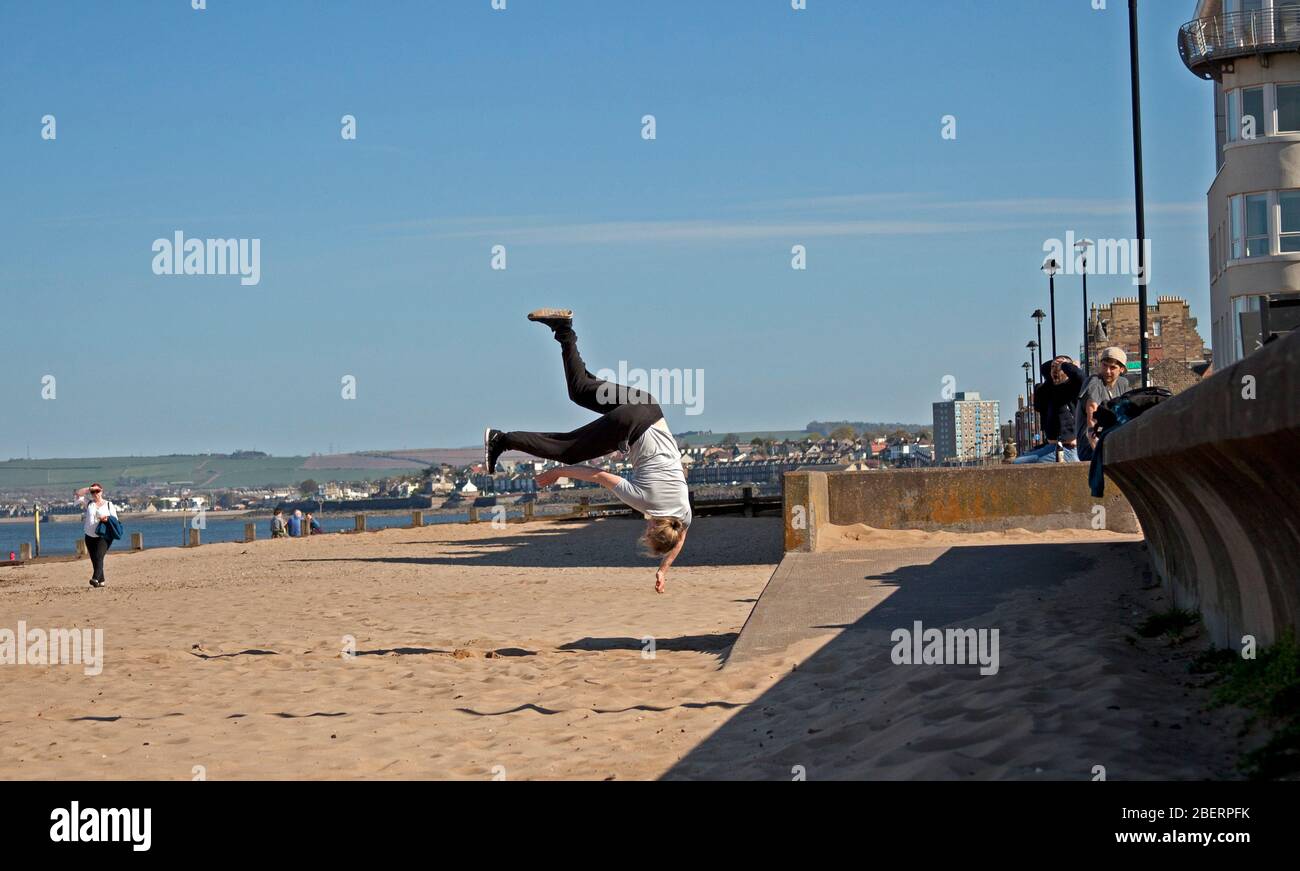 Portobello, Edinburgh, Schottland, Großbritannien. April 2020. Adam von Access Parkour, der führende Anbieter für den Unterricht in Parkour in Edinburgh und Schottland, limbing up mit einigen Zügen, während Klassen abgesagt werden und das Geschäft wegen Coronavirus Lockdown geschlossen ist. Parkour ist eine Trainingsdisziplin mit Bewegung, die aus militärischen Hindernisparcours Ausbildung entwickelt. Die Praktiker, die sogenannten Tracers oder Traceurs, wollen in einer komplexen Umgebung, ohne Hilfsausrüstung und auf die schnellste und effizienteste Weise von einem Punkt zum anderen gelangen. Quelle: Arch White/Alamy Live News Stockfoto