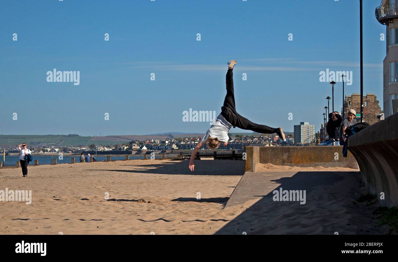 Portobello, Edinburgh, Schottland, Großbritannien. April 2020. Adam von Access Parkour, der führende Anbieter für den Unterricht in Parkour in Edinburgh und Schottland, limbing up mit einigen Zügen, während Klassen abgesagt werden und das Geschäft wegen Coronavirus Lockdown geschlossen ist. Parkour ist eine Trainingsdisziplin mit Bewegung, die aus militärischen Hindernisparcours Ausbildung entwickelt. Die Praktiker, die sogenannten Tracers oder Traceurs, wollen in einer komplexen Umgebung, ohne Hilfsausrüstung und auf die schnellste und effizienteste Weise von einem Punkt zum anderen gelangen. Quelle: Arch White/Alamy Live News Stockfoto