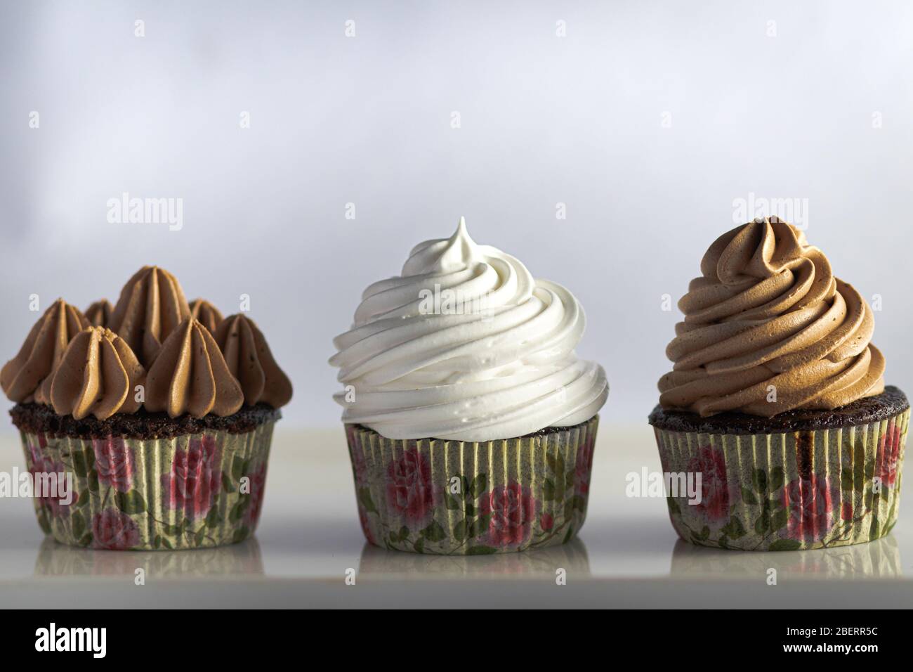 Drei Cupcakes mit Eispüsse auf weißem Hintergrund Stockfoto