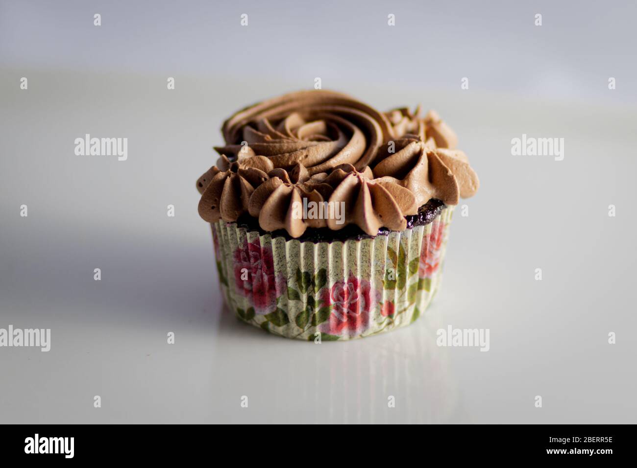 Ein Cupcake mit Blumenschokolade-Eispübel Stockfoto