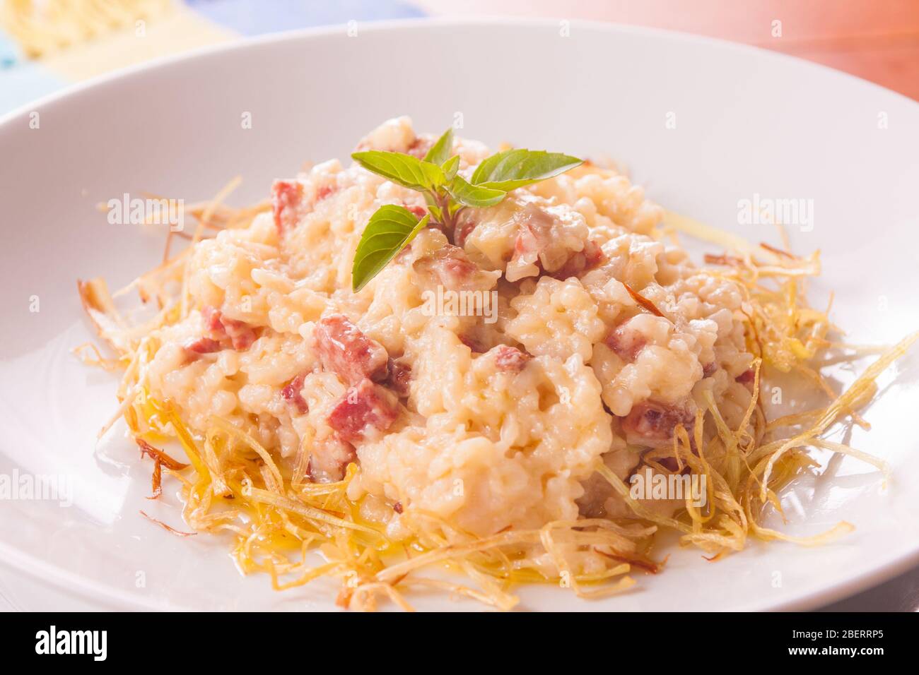 Käse und Speck Rissoto mit Scheiben Zwiebeln Stockfoto