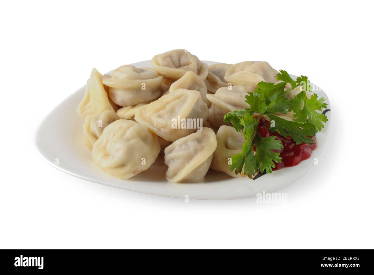 Gekochte Knödel mit Kerchup und einem Zweig Koriander auf einem Teller isoliert auf weiß Stockfoto