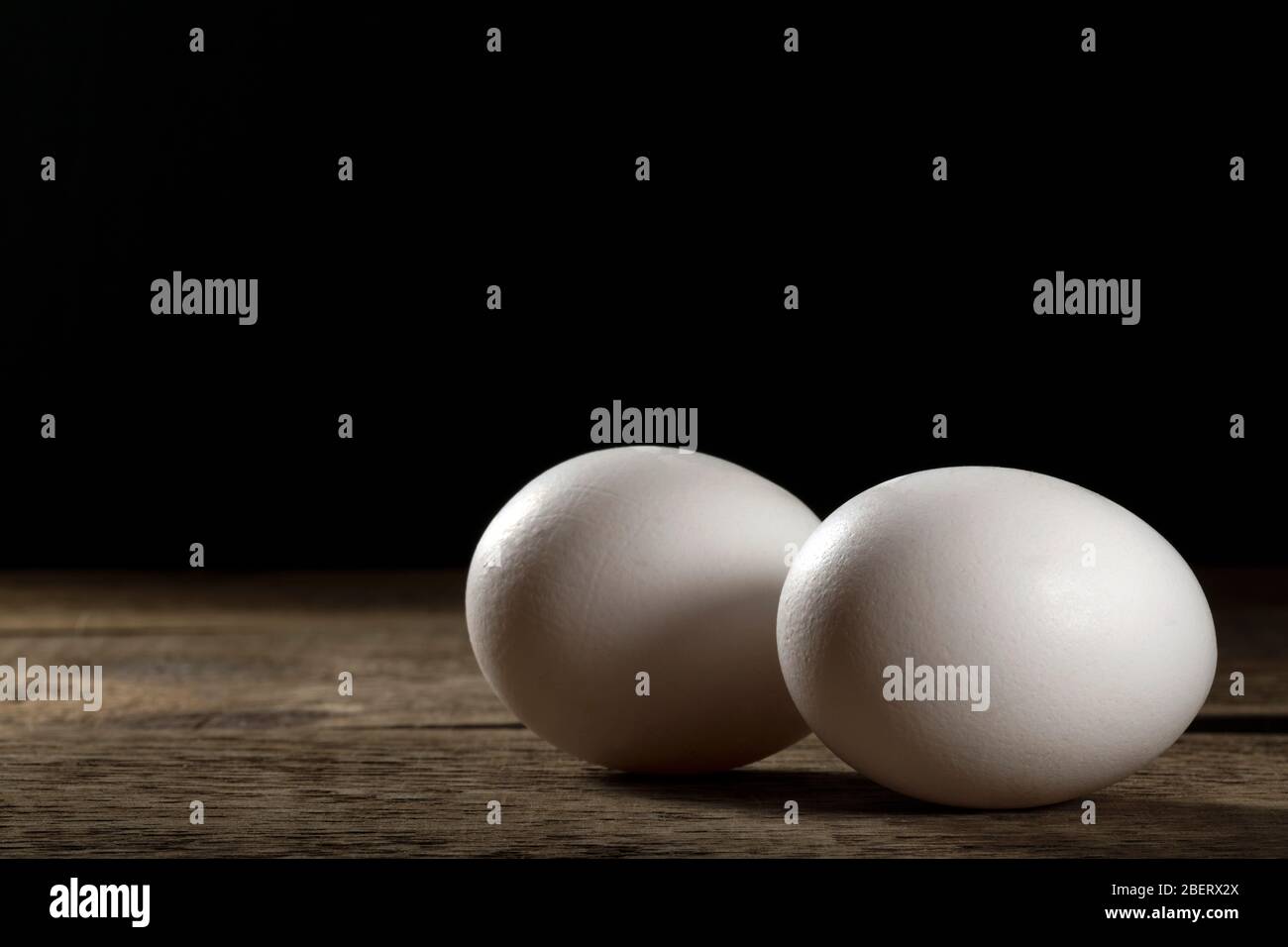 Zwei frische weiße Eier auf einem Holztisch. Stockfoto