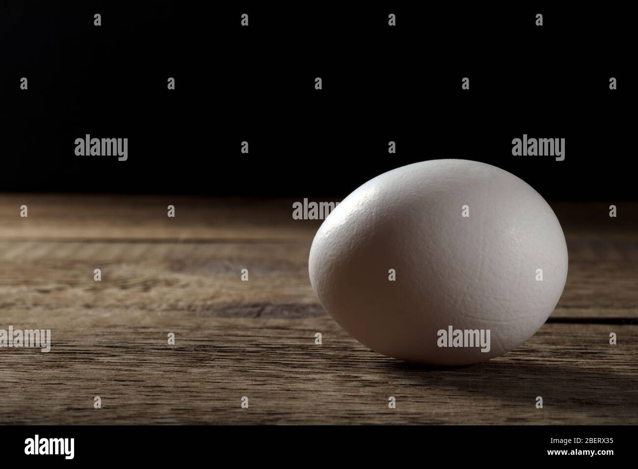 Ein frisches weißes Ei auf einem Holztisch. Stockfoto