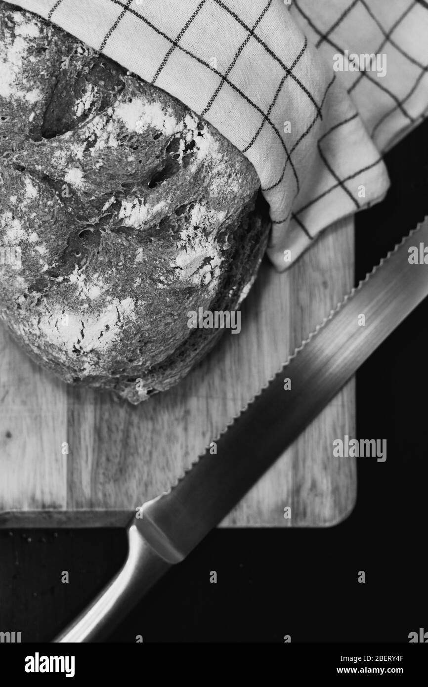 Frisches Brot, rustikales Brotmehl, Messer, Tablett Holzbrett Stockfoto