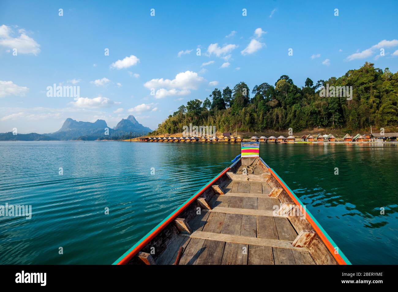 Traditionelles thailändisches Langschwanzboot aus Holz auf dem Cheow Lan See, das bei schwimmenden Bungalowhütten im Khao Sok Nationalpark, Thailand ankommt Stockfoto