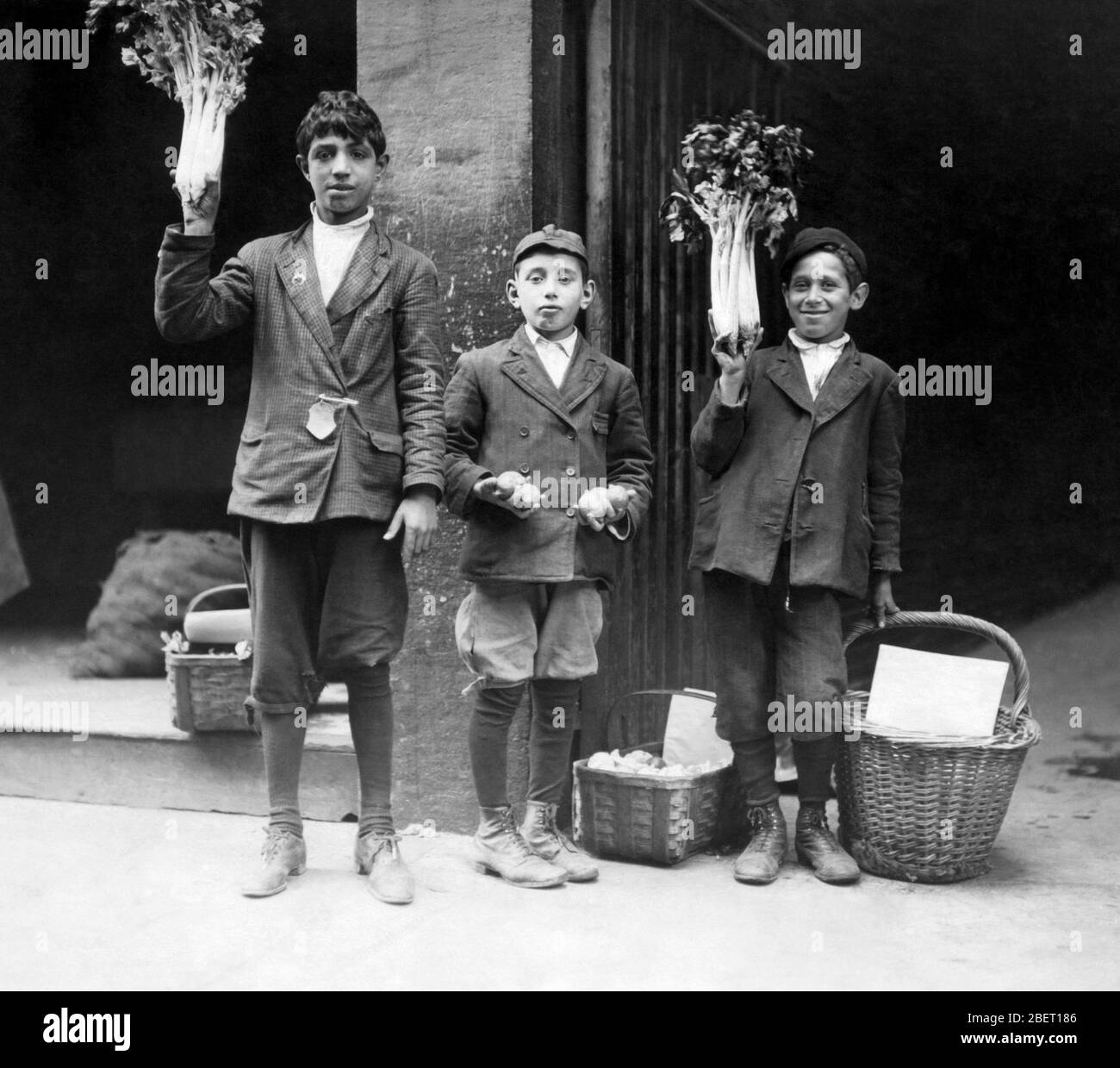 Drei Jungen verkaufen Obst und Gemüse auf der Straße, 1909. Stockfoto