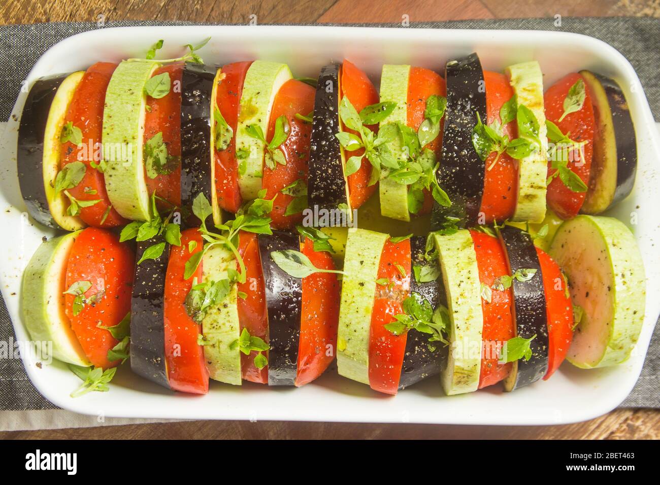 Ratatoullie. Eierpflanze, Tomaten und Zucchini. Rohkost über einem Holztisch Stockfoto