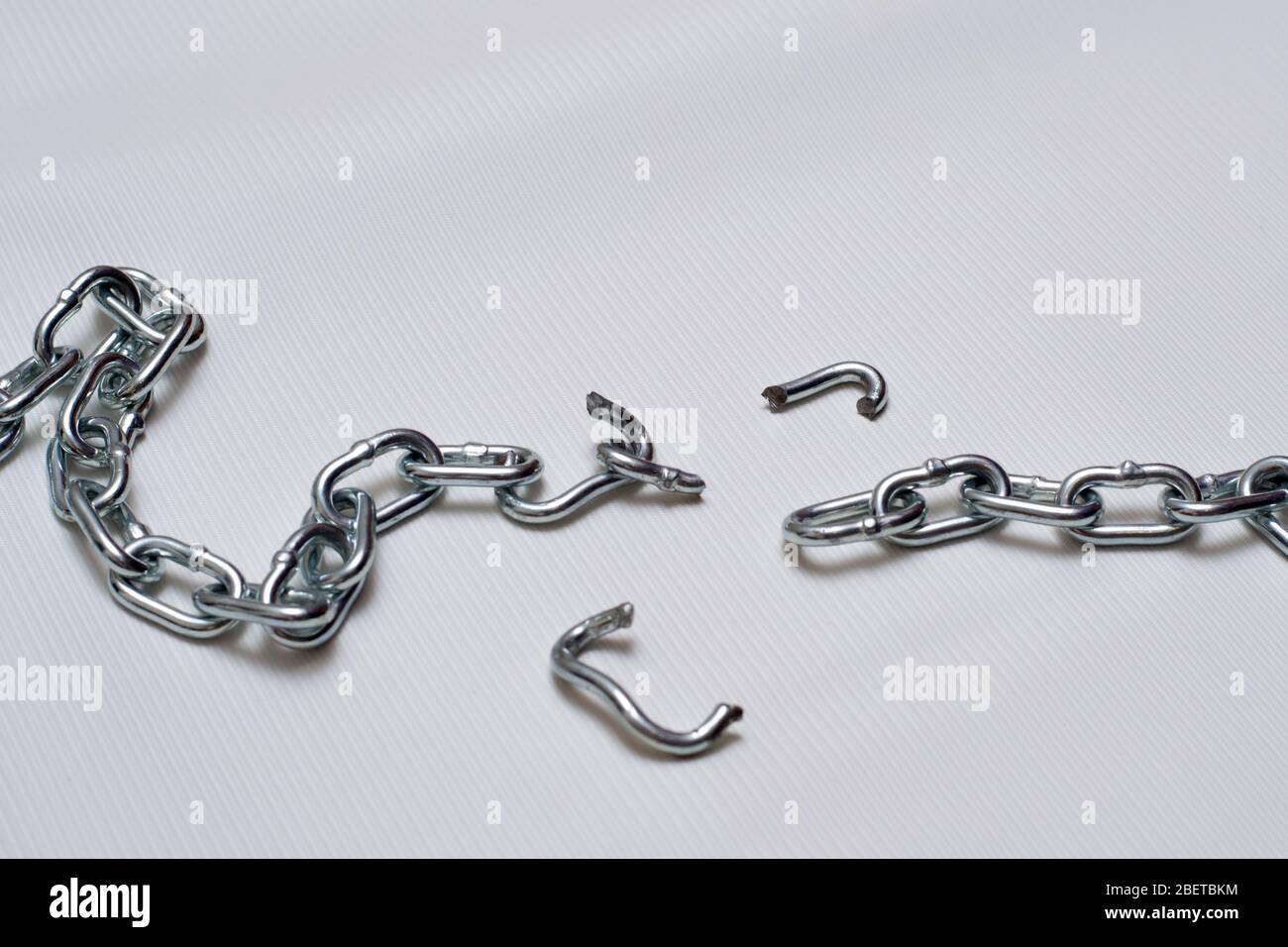 Foto von gebrochenen Metallkette auf weißem Hintergrund Stockfoto
