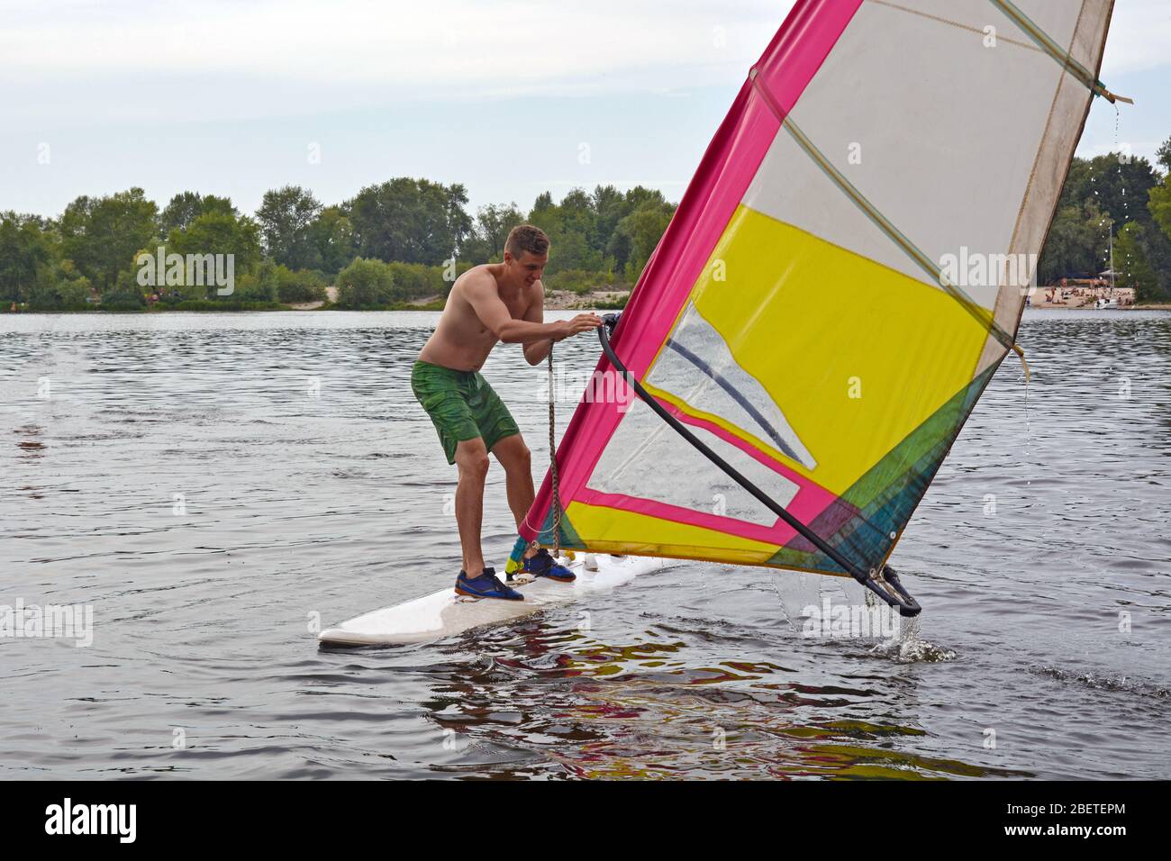 Man steht auf dem Board im Wasser Windsurfen Stockfoto