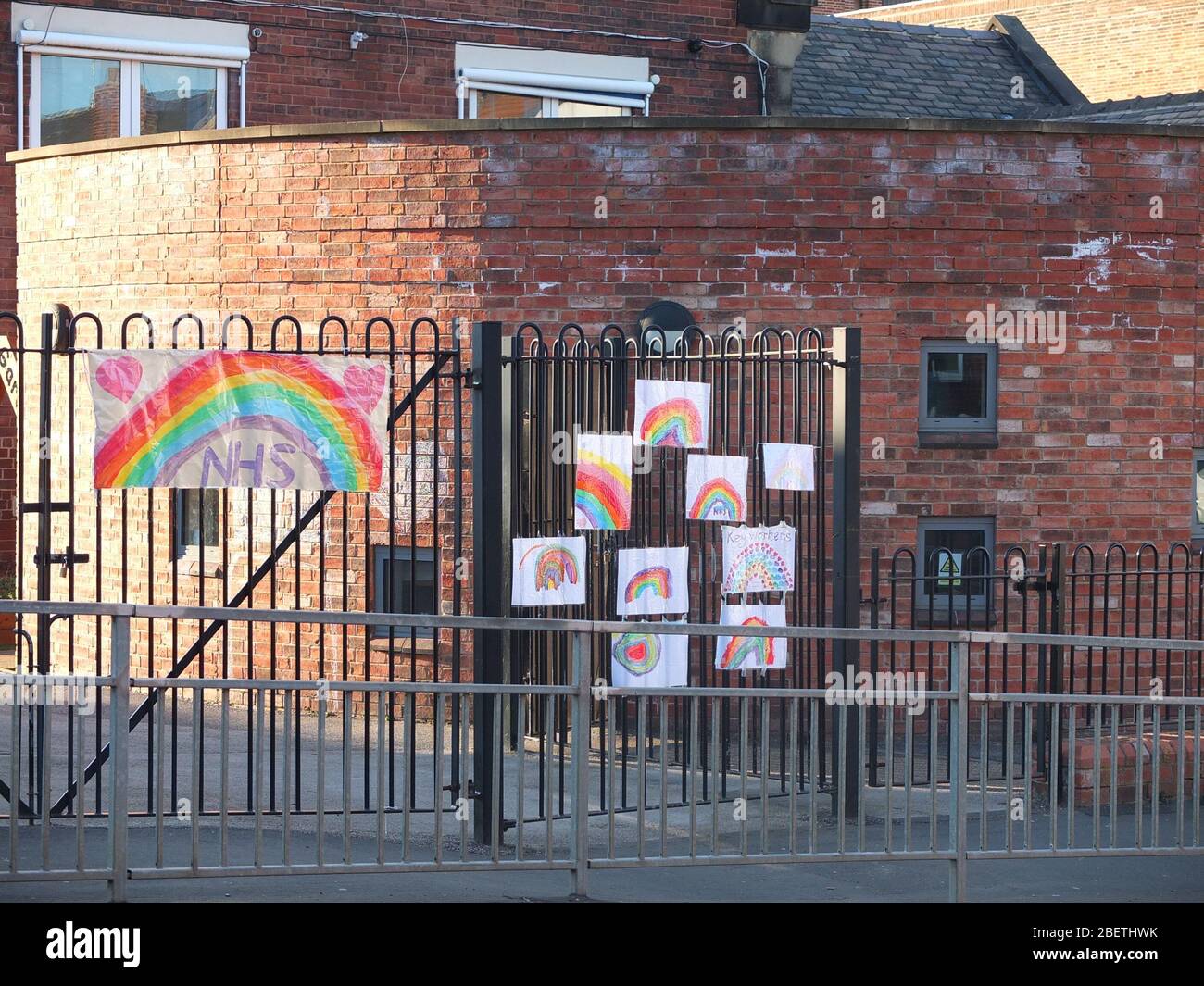 Kinderbilder von Regenbögen, die während der Coronavirus-Krise an den Geländern einer geschlossenen Grundschule in Sheffield UK festgeklebt wurden (Scared Heart School) Stockfoto
