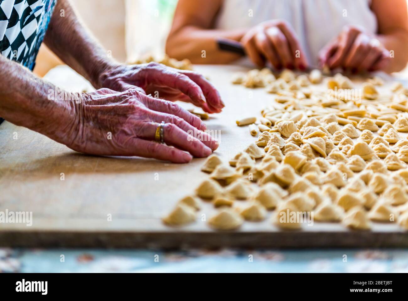 Eine alte Frau, während von Hand Orecchiette, typisch italienische Pasta zubereiten. Stockfoto