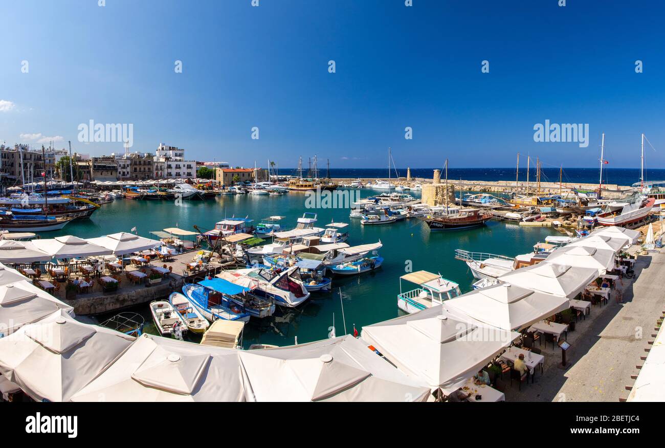 Panoramablick von der alten Burg von Marina Hafen und Hafen mit Yachten in Kyrenia Girne Stadt gegen blauen Himmel und Berge, Nordzypern Stockfoto