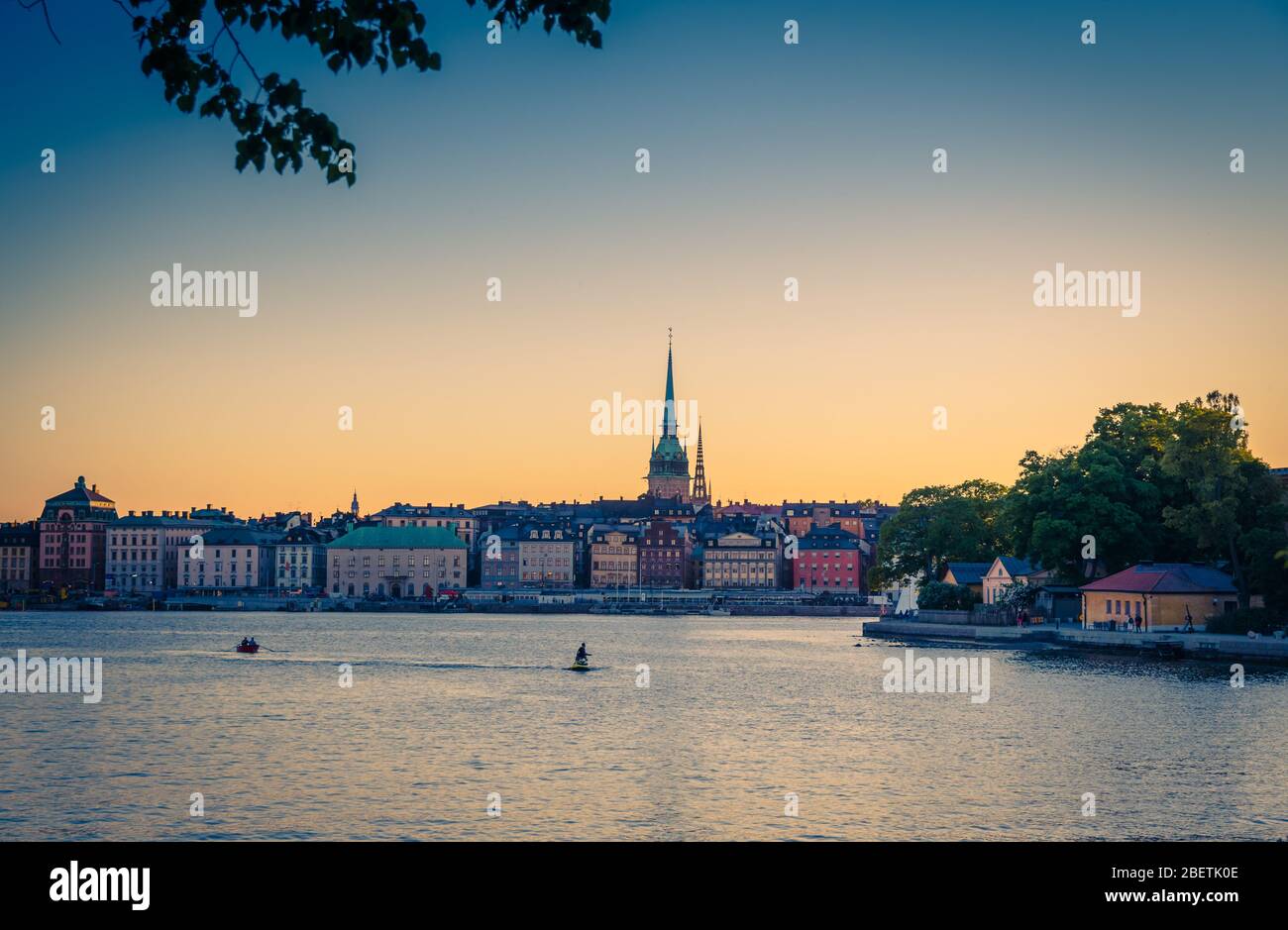 Altes historisches Stadtquartier Gamla Stan mit traditionellen typischen Gebäuden mit bunten Mauern, Park der Insel Skeppsholmen, Jet Ski und Boot auf dem See M Stockfoto