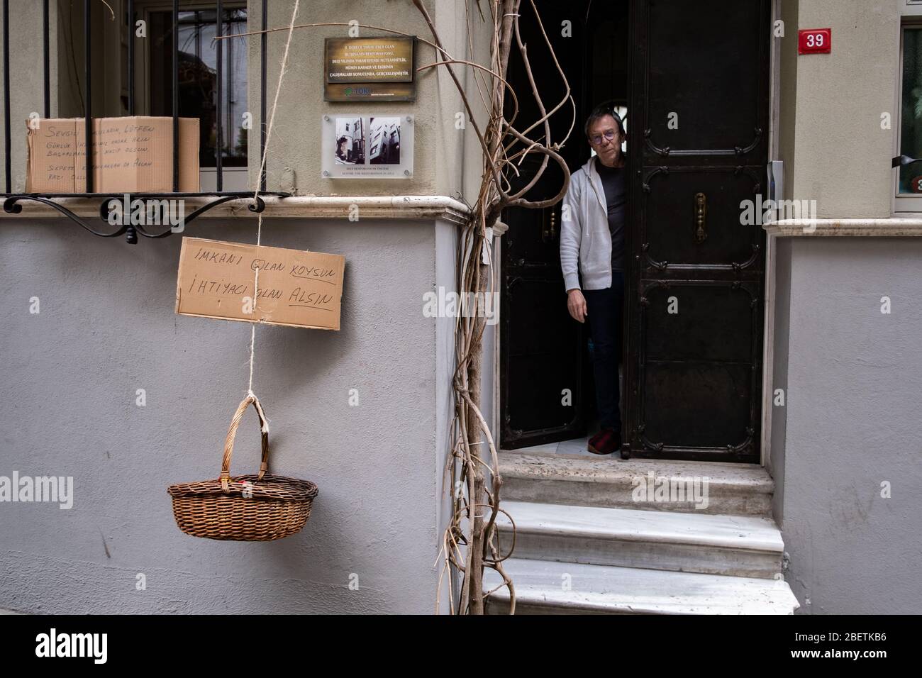 (200415) -- ISTANBUL, 15. April 2020 (Xinhua) -- Jeffrey Tucker wird am 15. April 2020 an der Tür seiner Wohnung in Istanbul, Türkei, gesehen. Jeffrey Tucker, ein Istanbuler Einwohner, ließ am Mittwoch einen Korb mit Gemüsestücken, einer Schachtel Pasta und Obst aus dem Fenster seiner Wohnung im Zentrum Istanbuls herunter. Tucker fügte eine Notiz auf dem Korb an, die lautete: "Wer in Not ist, kann nehmen, und wer etwas beitragen will, kann mehr setzen." Inspiriert von einer Praxis, die in Italien viral wurde, entschied Tucker, die gleiche Kampagne in der Türkei für diejenigen, die finanziell sind zu starten Stockfoto