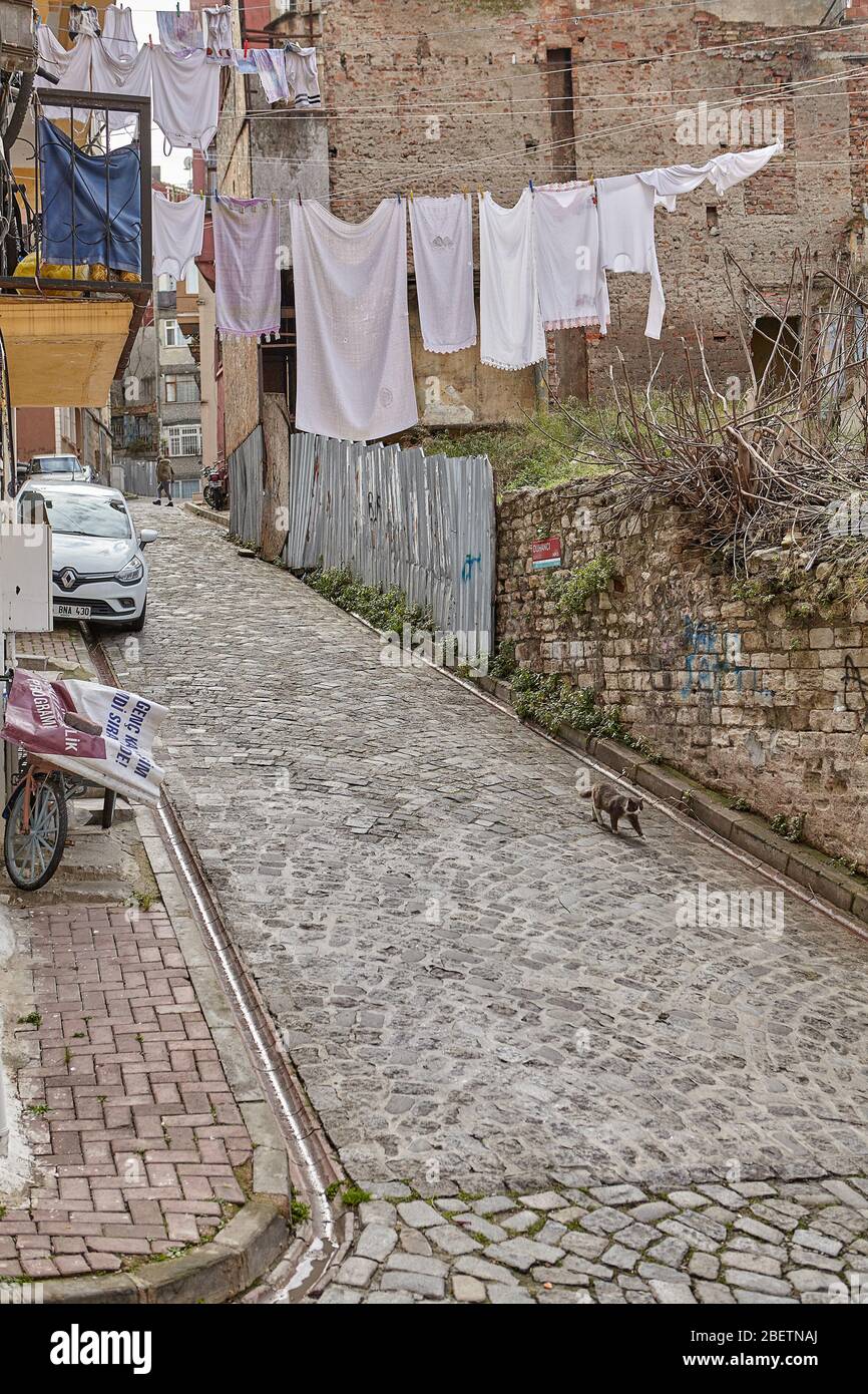 Istanbul, Türkei - 12. Februar 2020: Enge Duhanci Straße im Balat Viertel oder jüdischen Viertel des Fatih Viertels. Nasse Kleidung hängt an einem Seil Stockfoto