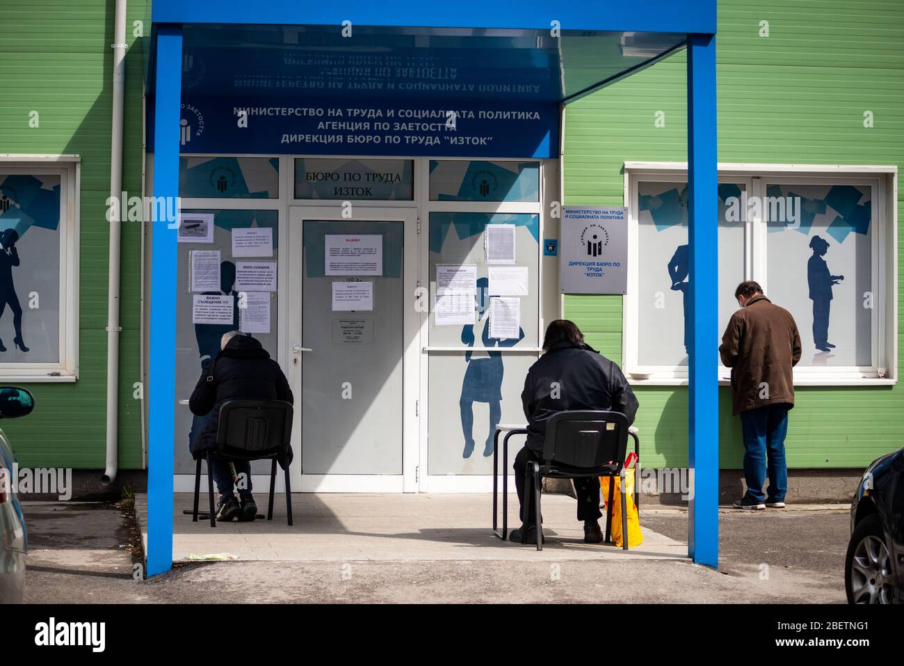 Sofia, Bulgarien. 15. April 2020. Arbeitslose, die Schutzmaske tragen, warten und füllen Formulare auf spontanen sozialen Distanzierungstabellen vor einem lokalen Arbeitszentrum der Abteilung für Sozialschutz aus. Die Arbeitslosigkeit im Land ist auf 7% wegen des Pandemischen Coronavirus Covid gestiegen - 19 nach Jahren stabil niedriger Raten bei rund 3.5%. Stockfoto