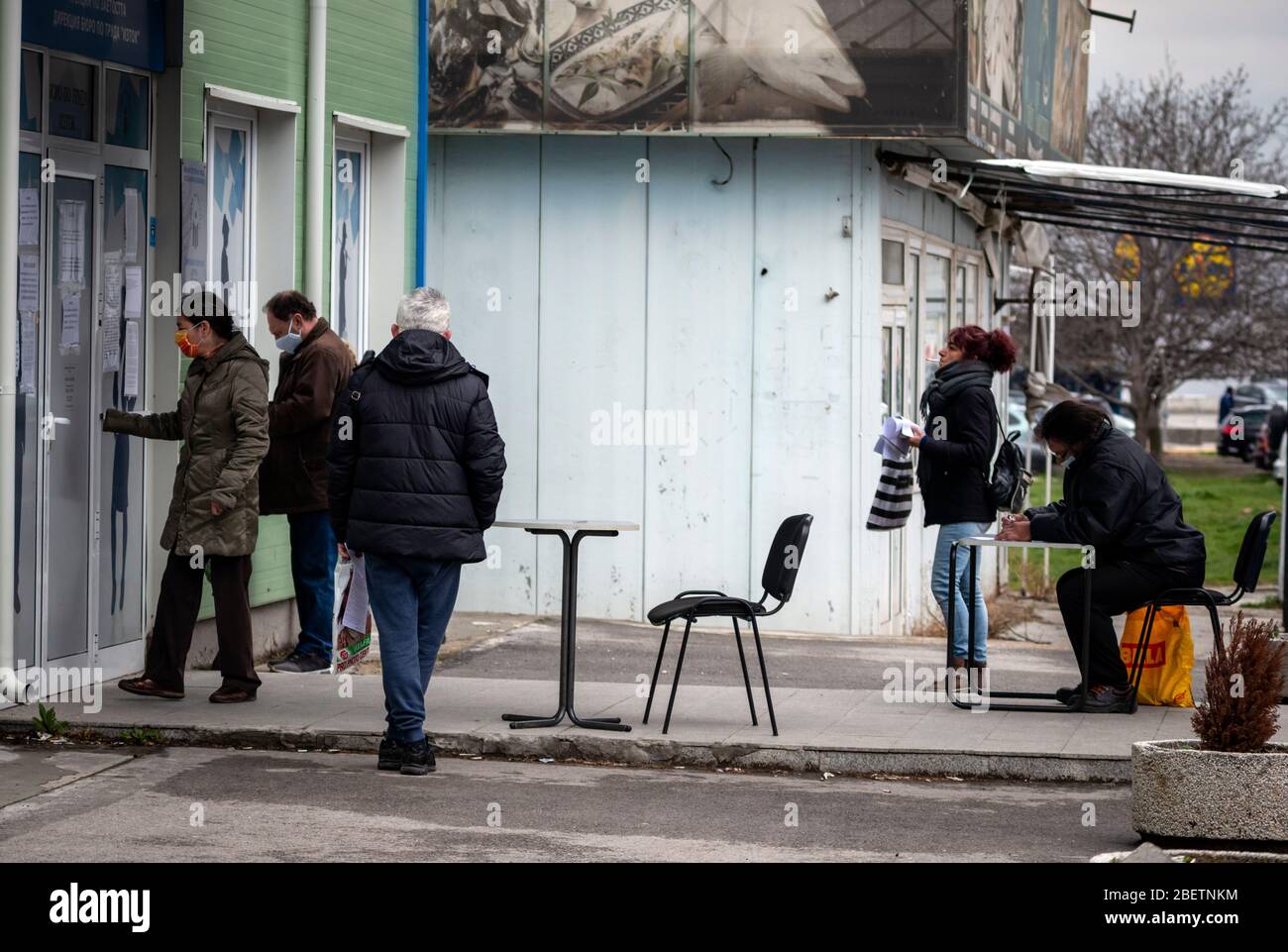 Sofia, Bulgarien. 15. April 2020. Arbeitslose, die Schutzmaske tragen, warten und füllen Formulare auf spontanen sozialen Distanzierungstabellen vor einem lokalen Arbeitszentrum der Abteilung für Sozialschutz aus. Die Arbeitslosigkeit im Land ist auf 7% wegen des Pandemischen Coronavirus Covid gestiegen - 19 nach Jahren stabil niedriger Raten bei rund 3.5%. Stockfoto