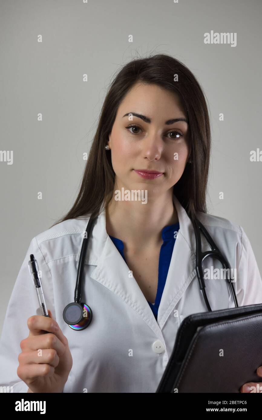 Weibliche medizinische Anbieter Kopf Aufnahme Porträt Blick auf Kamera isoliert auf grauem Hintergrund Stockfoto