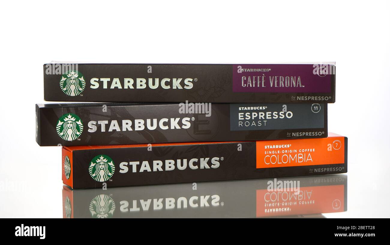 Eine Auswahl an Starbucks Kaffee Nespresso Boxen in verschiedenen Geschmacksrichtungen auf weißem Hintergrund mit Reflektion. Stockfoto