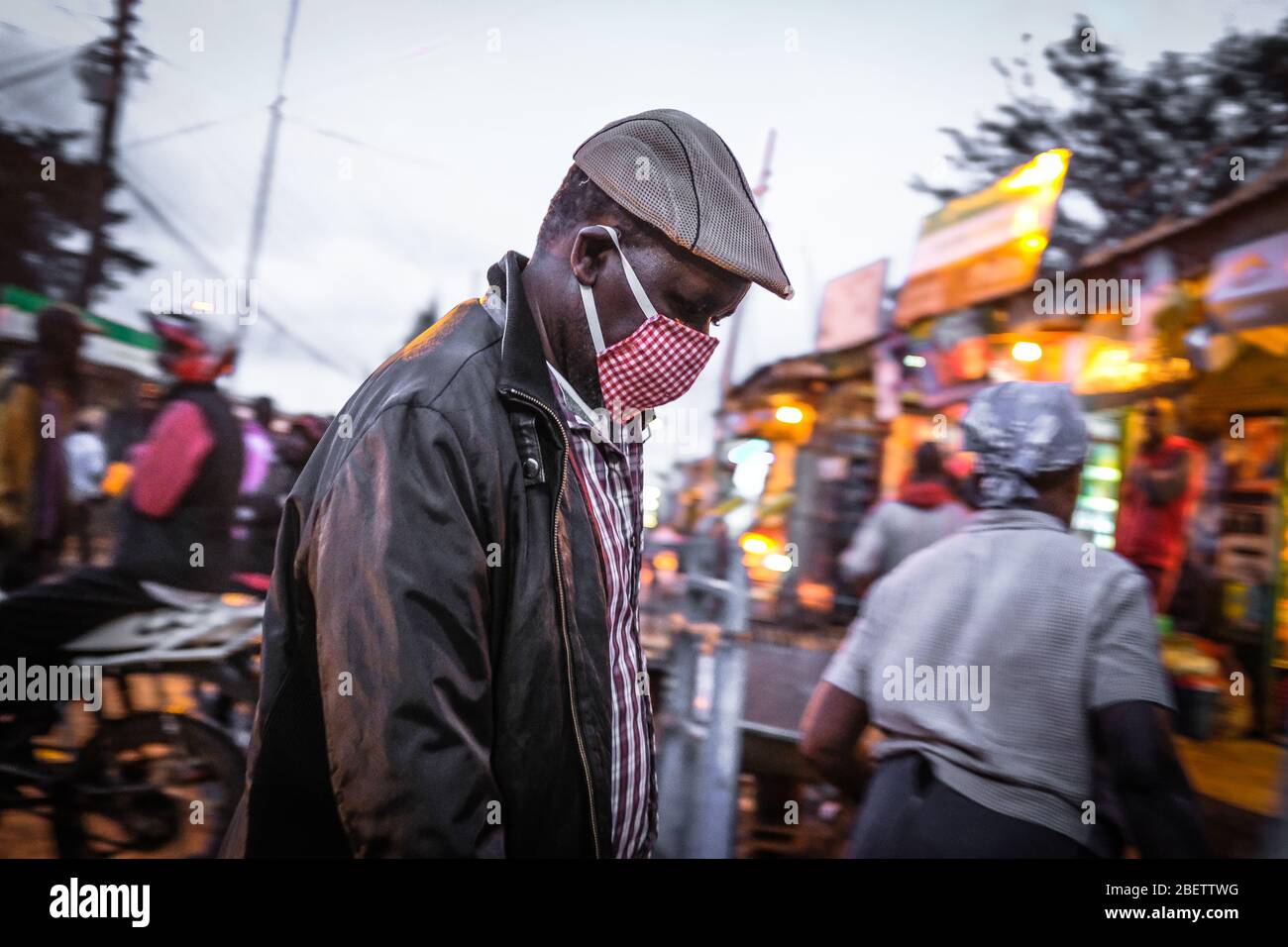 Ein Mann, der eine Gesichtsmaske trägt, um die Ausbreitung des Coronavirus zu verhüten, geht an den belebten Straßen von Kibera vorbei.Trotz der Ausgangssperre durch die Corona Virus Pandemie gehen die meisten Bewohner in den Slums von Kibera wie gewohnt weiter. Die meisten Einwohner würden ihr Geschäft ohne Gesichtsmasken und Handdesinfektionsmittel fortsetzen, eine Situation, die zur einfachen und schnellen Ausbreitung des Corona Virus von einer Person zur anderen führen könnte. Stockfoto