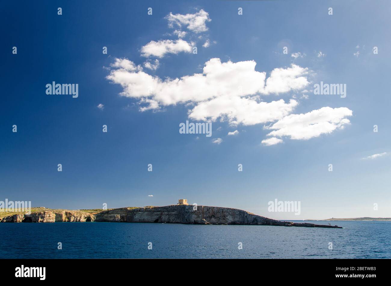 Blauer Himmel und weiße Wolken über dem Marien-Turm der Wachturm auf der Insel Comino oder Kemmuna des maltesischen Archipels in der Mediterra Stockfoto