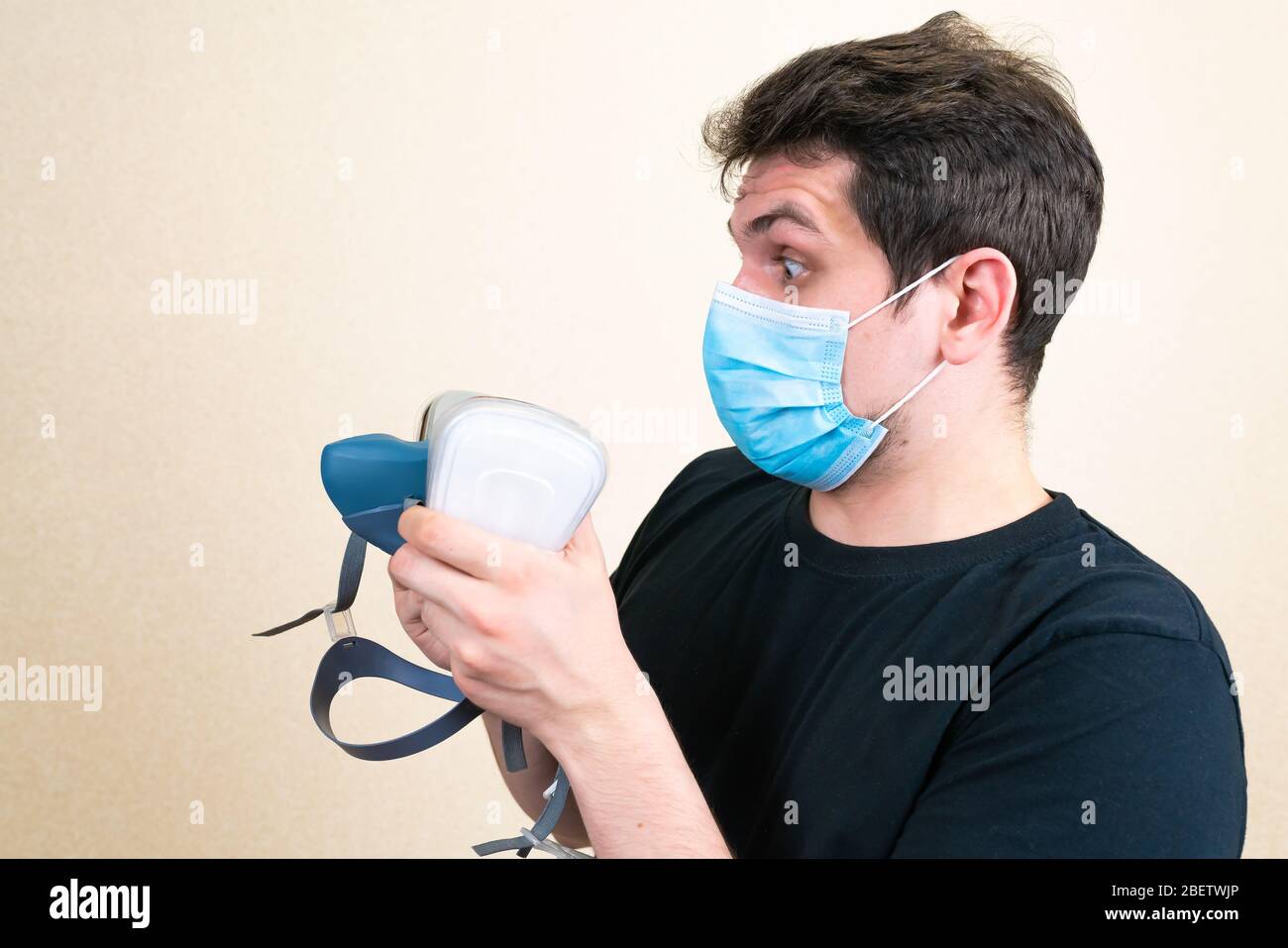 Junger Mann in blauen medizinischen Maske überrascht mit hoher Effizienz Atemschutzmaske Stockfoto
