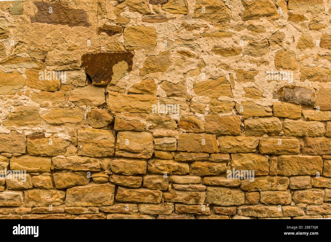 Helle Sandsteinwand mit dunklem Stein oben nicht verfugt Nahaufnahme Stockfoto