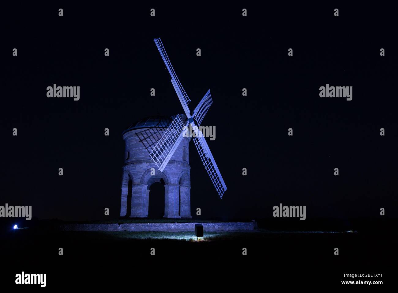 Chesterton, Warwickshire, Großbritannien. April 2020. Die unter Denkmalschutz stehende Windmühle aus dem 17. Jahrhundert in Chesterton, in der Nähe von Leamington Spa, Warwickshire, ist mit blauem Licht zur Unterstützung des NHS und anderer wichtiger Arbeiter beleuchtet. Quelle: Peter Lopeman/Alamy Live News Stockfoto