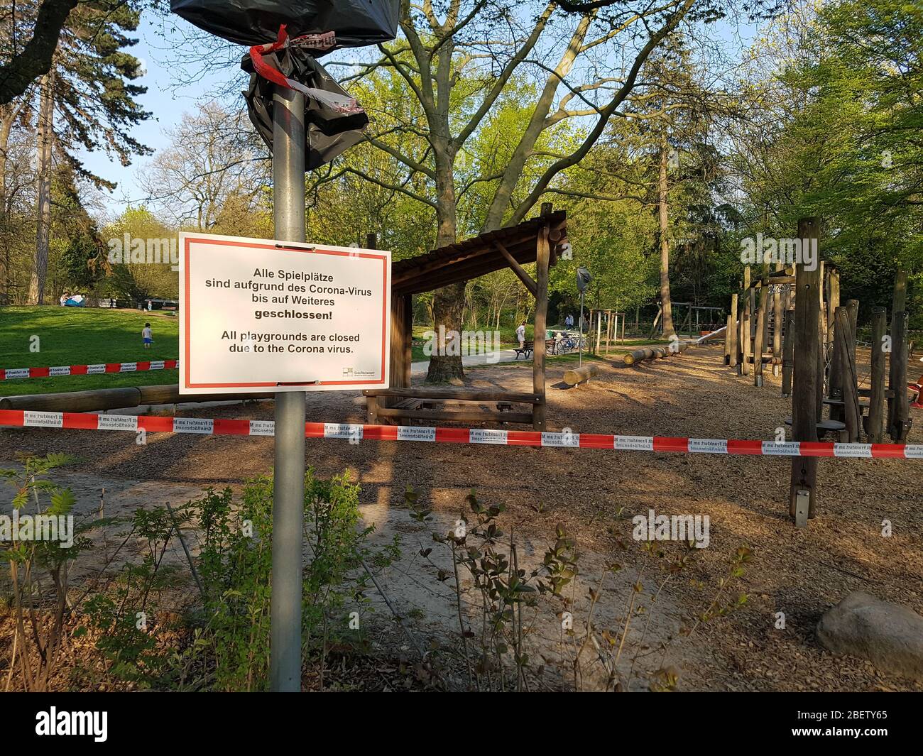 Leerer, verlassene Kinderspielplatz mit Polizeischutzband und Warnschild geschlossen - Verbot, Spielfeld zu betreten - Corona Virus covid-19 Stockfoto