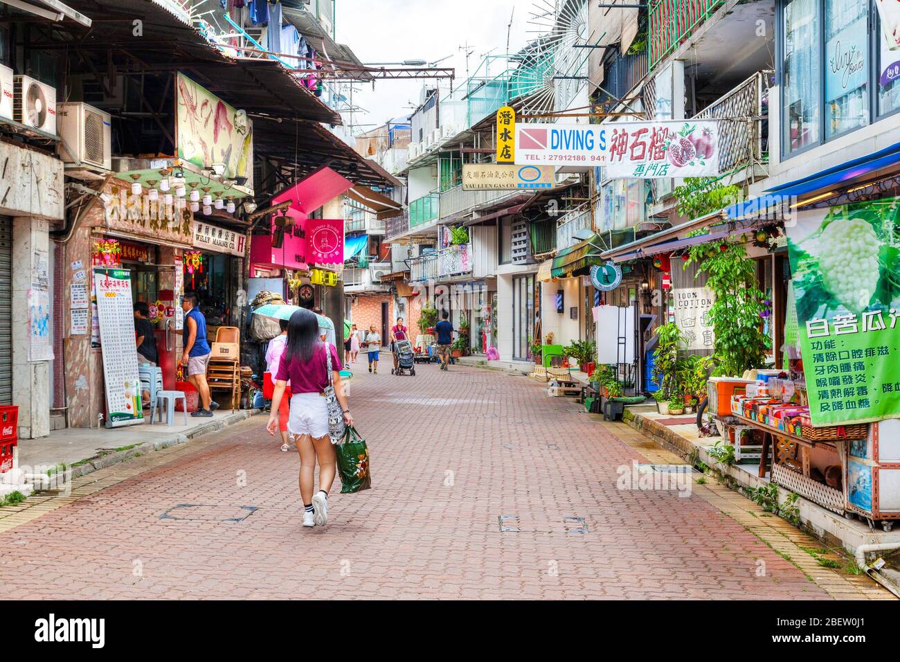 Hongkong, Hongkong SAR - 14. Juli 2017: Bewohner und Besucher schlendern entlang der Hauptstraße im alten Sai Kung Dorf. Die lockste Küstenstadt Stockfoto