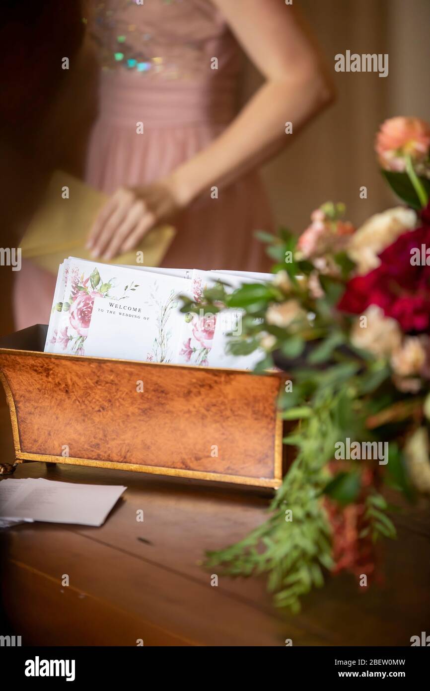 Hochzeitskarte Ankündigungen in einem dekorativen Behälter am Eingang einer Hochzeitszeremonie Flur mit Drehbuch-Schrift und Blumen verziert Stockfoto