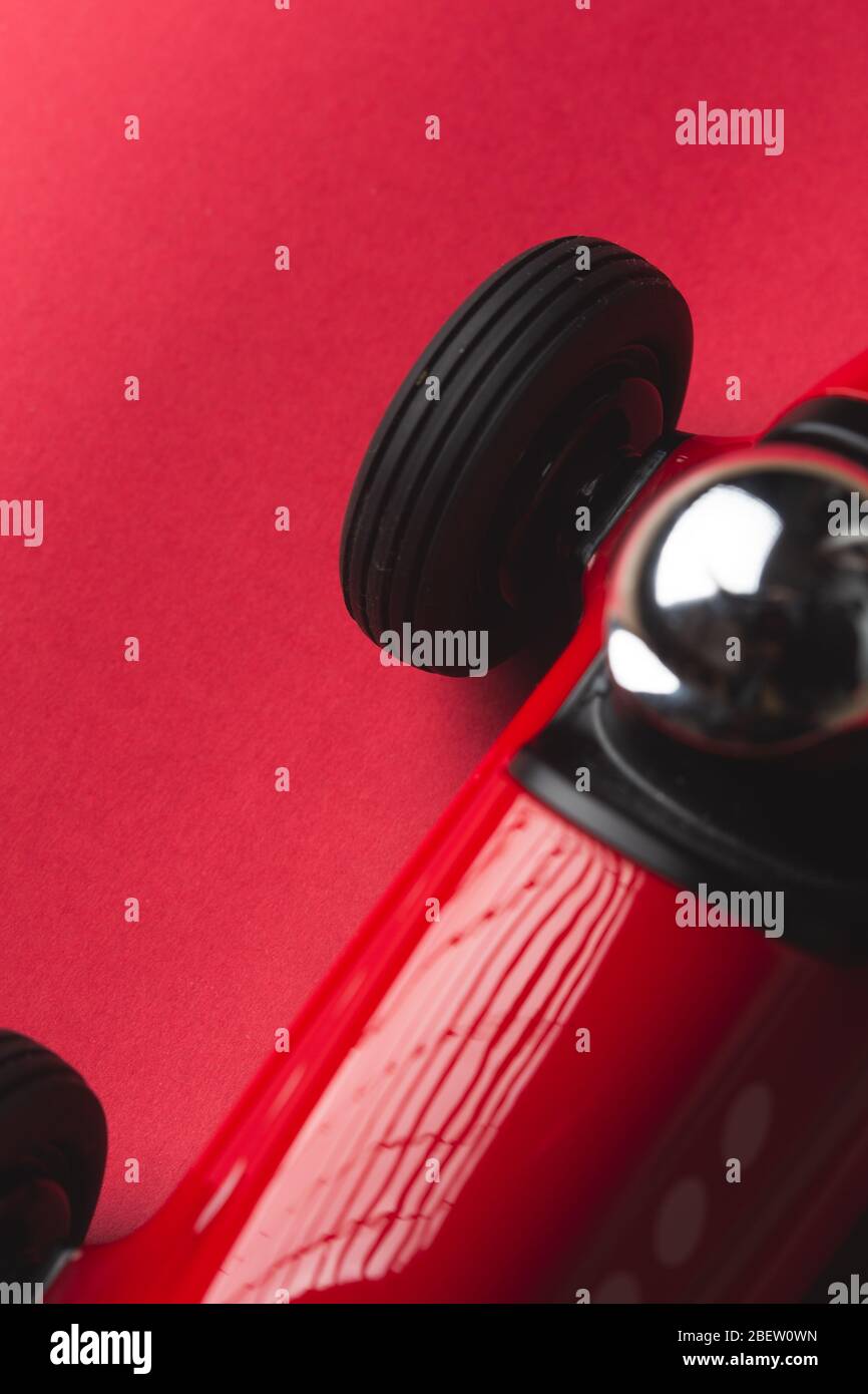 Rotes Spielzeug Oldtimer mit Nummer fünf auf einem Teller Nahaufnahme noch auf einem roten Hintergrund Stockfoto