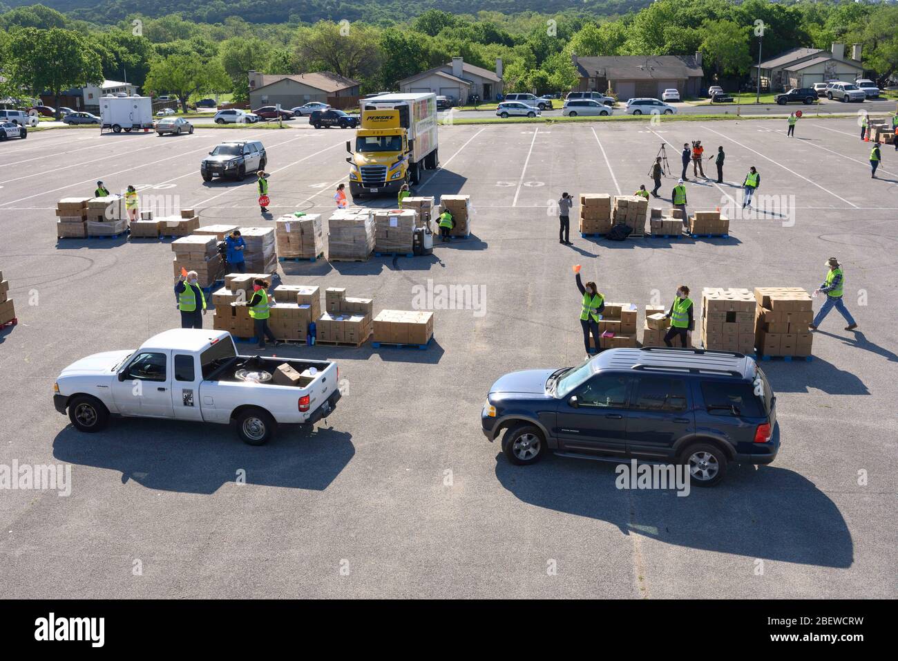 Central Texas Food Bank Freiwillige arbeiten, um 28-Pfund-Boxen von Klammern in Fahrzeuge während eines Lebensmittel-Werbegeschenk in Austin, Texas zu laden. Fast 1,500 Familien nahmen als Reaktion auf den Verlust von Arbeitsplätzen durch die umfassende Coronavirus-Pandemie und die allgemeinen wirtschaftlichen Folgen von Texas Kisten auf Stockfoto