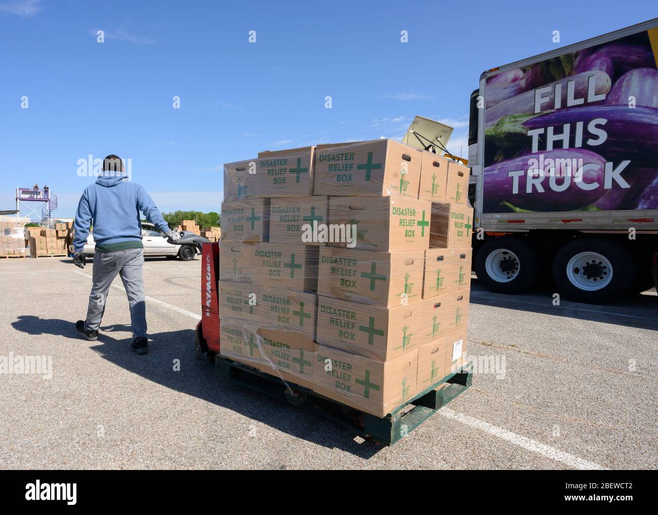 Central Texas Food Bank Freiwillige arbeiten, um 28-Pfund-Boxen von Klammern in Fahrzeuge während eines Lebensmittel-Werbegeschenk in Austin, Texas zu laden. Fast 1,500 Familien nahmen als Reaktion auf den Verlust von Arbeitsplätzen durch die umfassende Coronavirus-Pandemie und die allgemeinen wirtschaftlichen Folgen von Texas Kisten auf Stockfoto