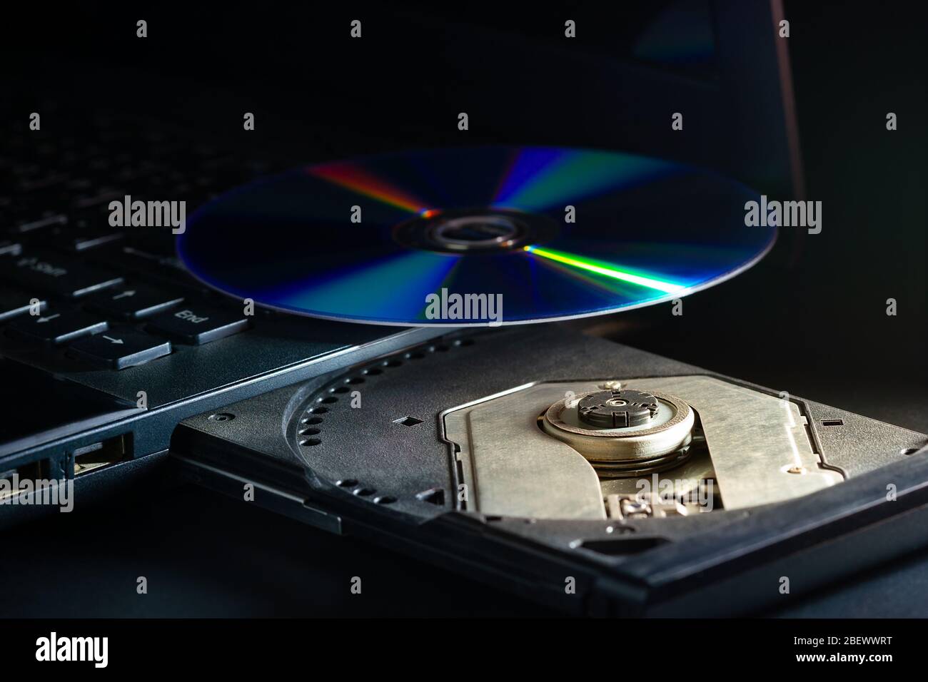 CD auf dem computer notebook cd-rom in der Dunkelheit. Konzept der technologischen Fortschritte in der Computer Datenerfassungssystemen. Stockfoto