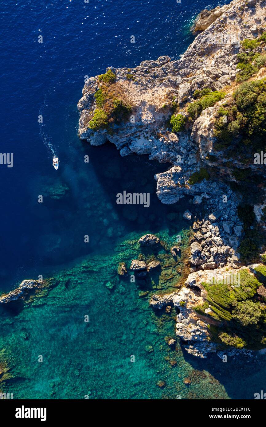 Abgeschiedene Lagune in mediterraner Meeresantenne. Schöne Bucht in Griechenland mit einem Boot herumschwimmend Stockfoto