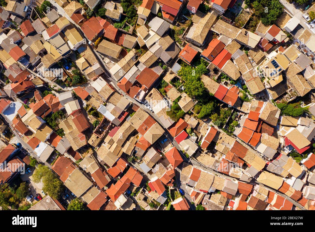 Helle Ziegeldächer, die von einer Drohne geschossen wurden. Dachantenne mit roten Fliesen im griechischen Dorf. Alte mediterrane Architektur. Stockfoto