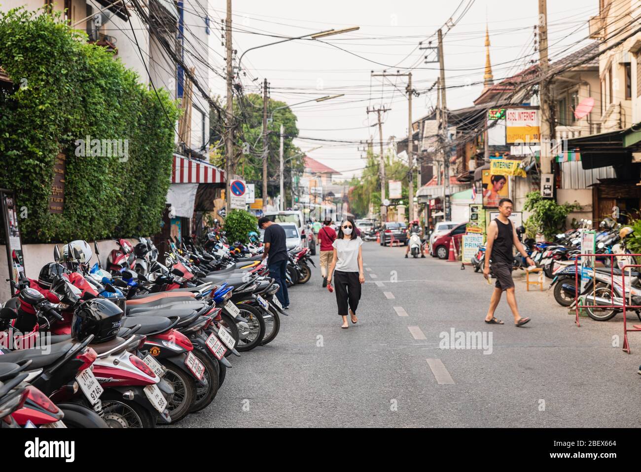 Chianf Mai, Thailand - 9. Februar 2020: Frau in schwarzer Maske auf der Straße voller Motorräder in der touristischen Stadt Chiang Mai in Nord-Thailand Stockfoto