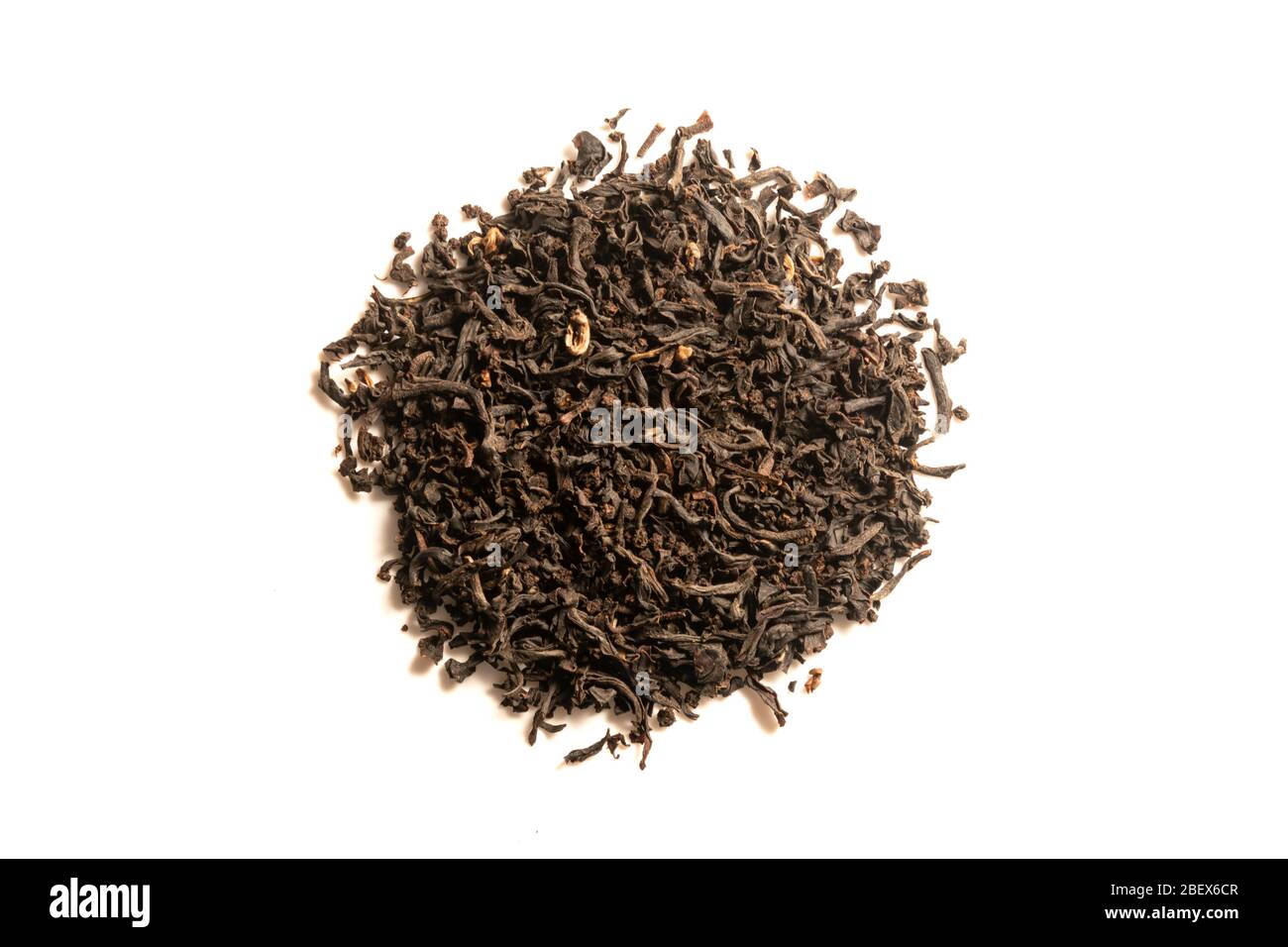 Haufen von getrockneten schwarzen Teeblättern auf weißem Hintergrund isoliert. Jeden Tag losen Tee mit ganzen Blättern zubereiten. Draufsicht. Stockfoto
