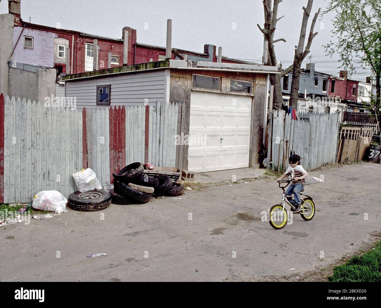 Juni 1998 - Junge Kind reiten Fahrrad- und tragen Cape in städtischen Gasse Stockfoto