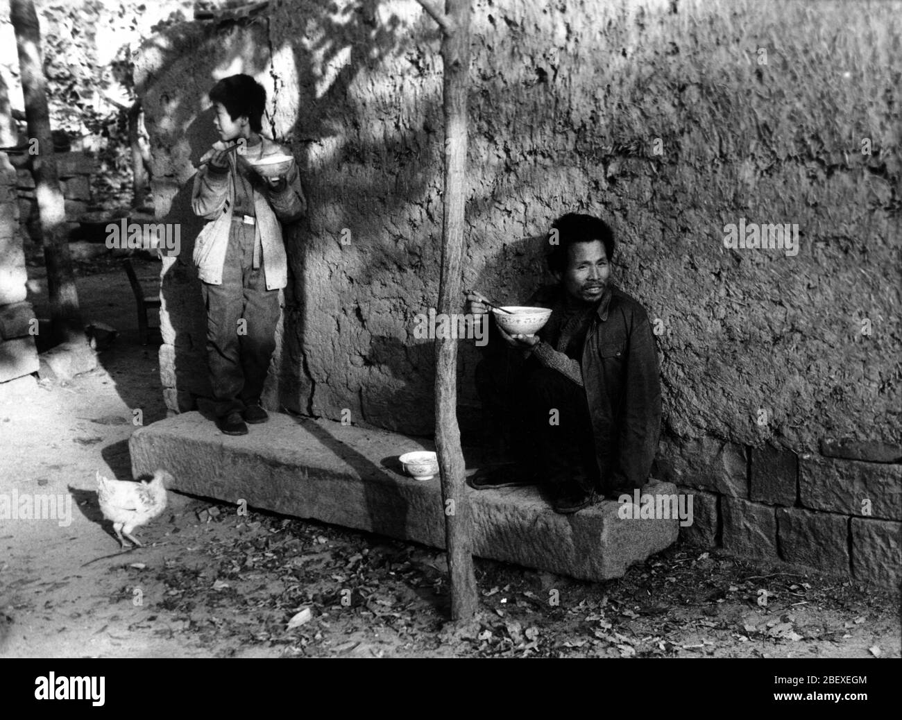 1990 ländlichen Henan Vater und Sohn essen draußen Stockfoto
