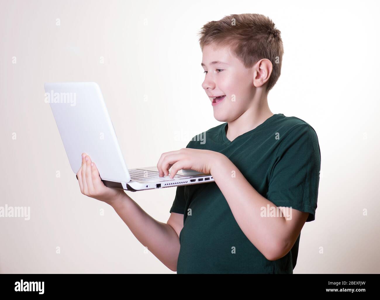 Aufgeregt 10 - 12 Jahre alten Jungen (Teenager) verwenden seinen Laptop Stockfoto