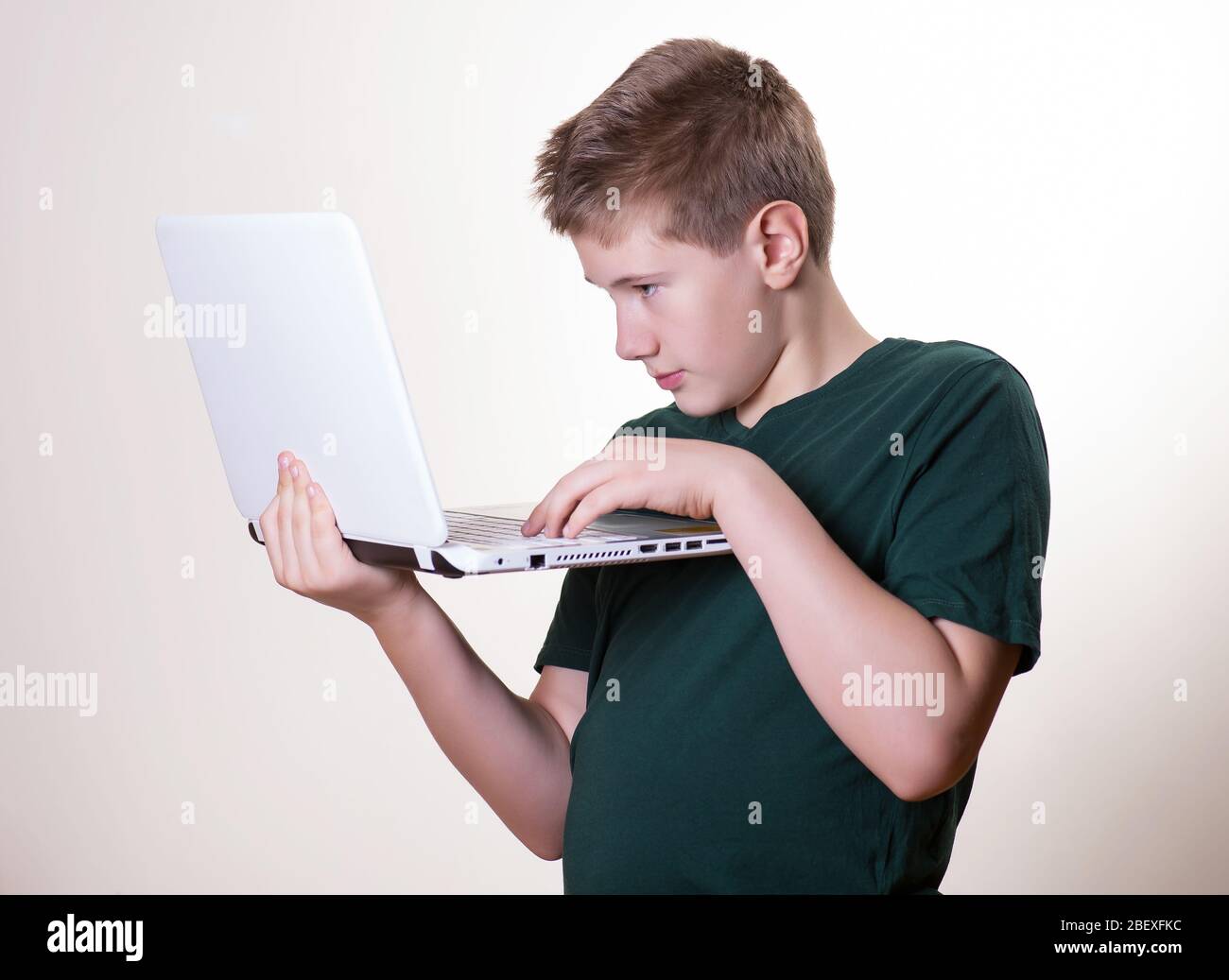 Konzentriert 10 - 12 Jahre alten Jungen (Teenager) auf der Suche nach einigen Informationen online, Arbeit mit Laptop Stockfoto