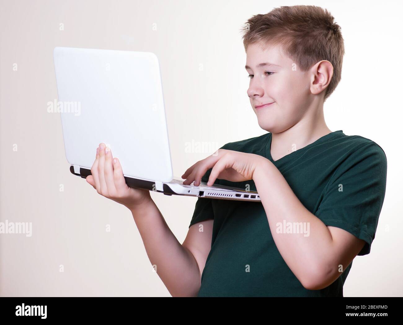 Aufgeregt 10 - 12 Jahre alten Jungen (Teenager) verwenden seinen Laptop Stockfoto