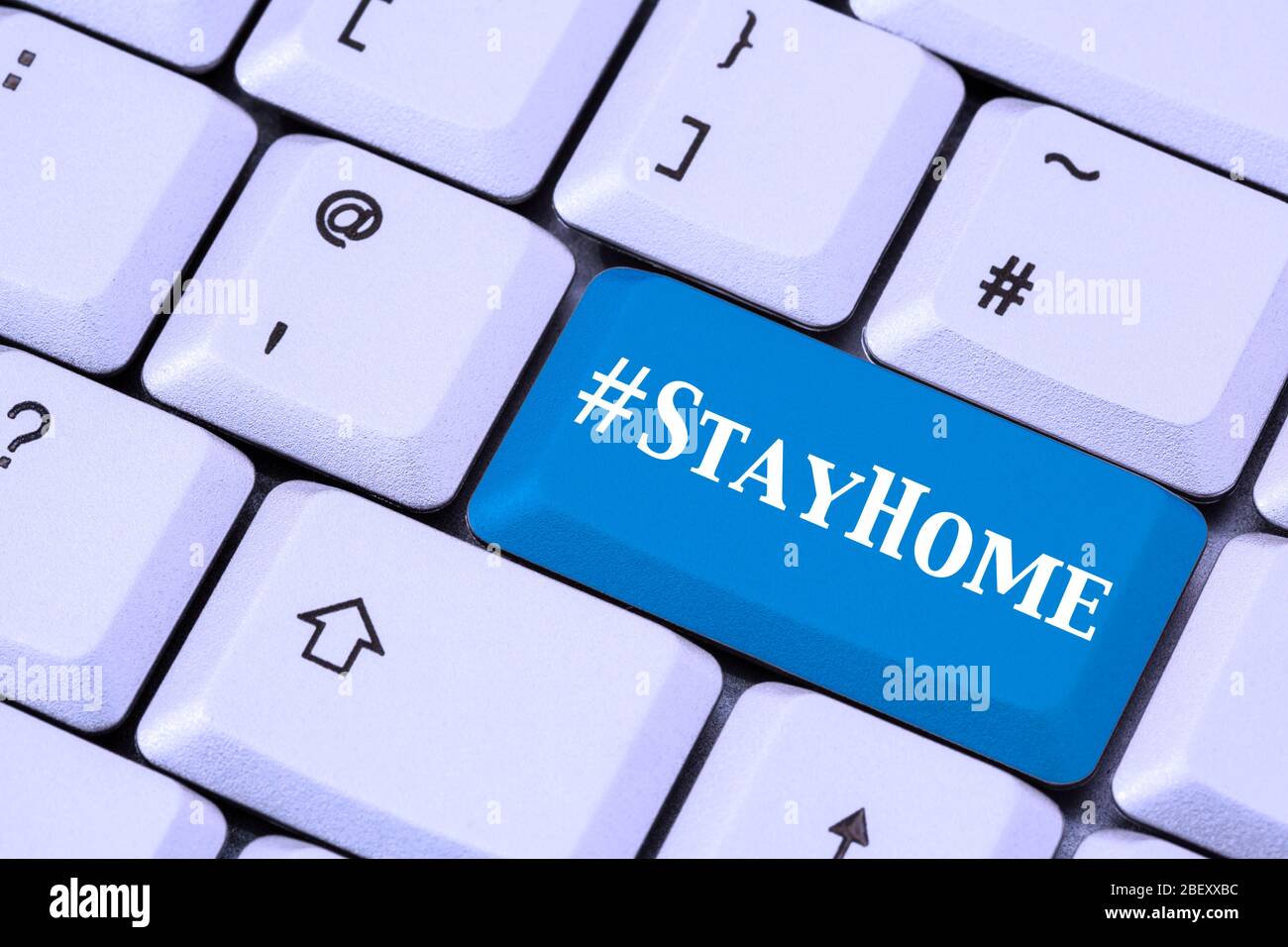 Eine Tastatur mit #StayHome auf einer blauen ENTER-Taste. Covid-19 Coronavirus-Pandemie bleibt zu Hause Lockdown-Konzept im April 2020. England, Großbritannien Stockfoto